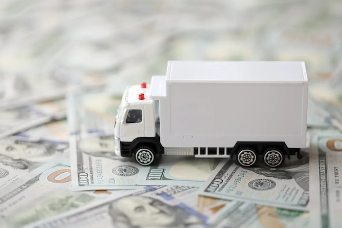Samochód dostawczy na tle setek dolarów banknotów