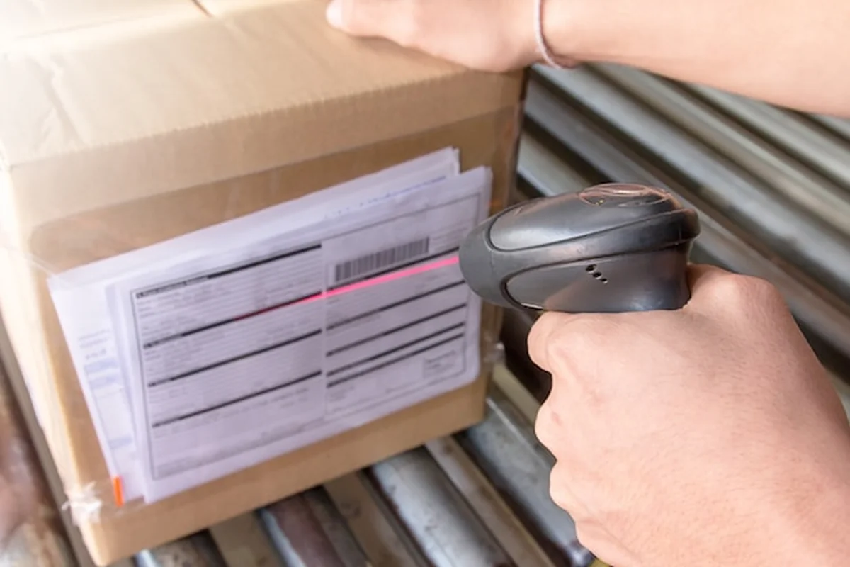 Pracownik magazynu skanuje produkt skanerem kodów kreskowych