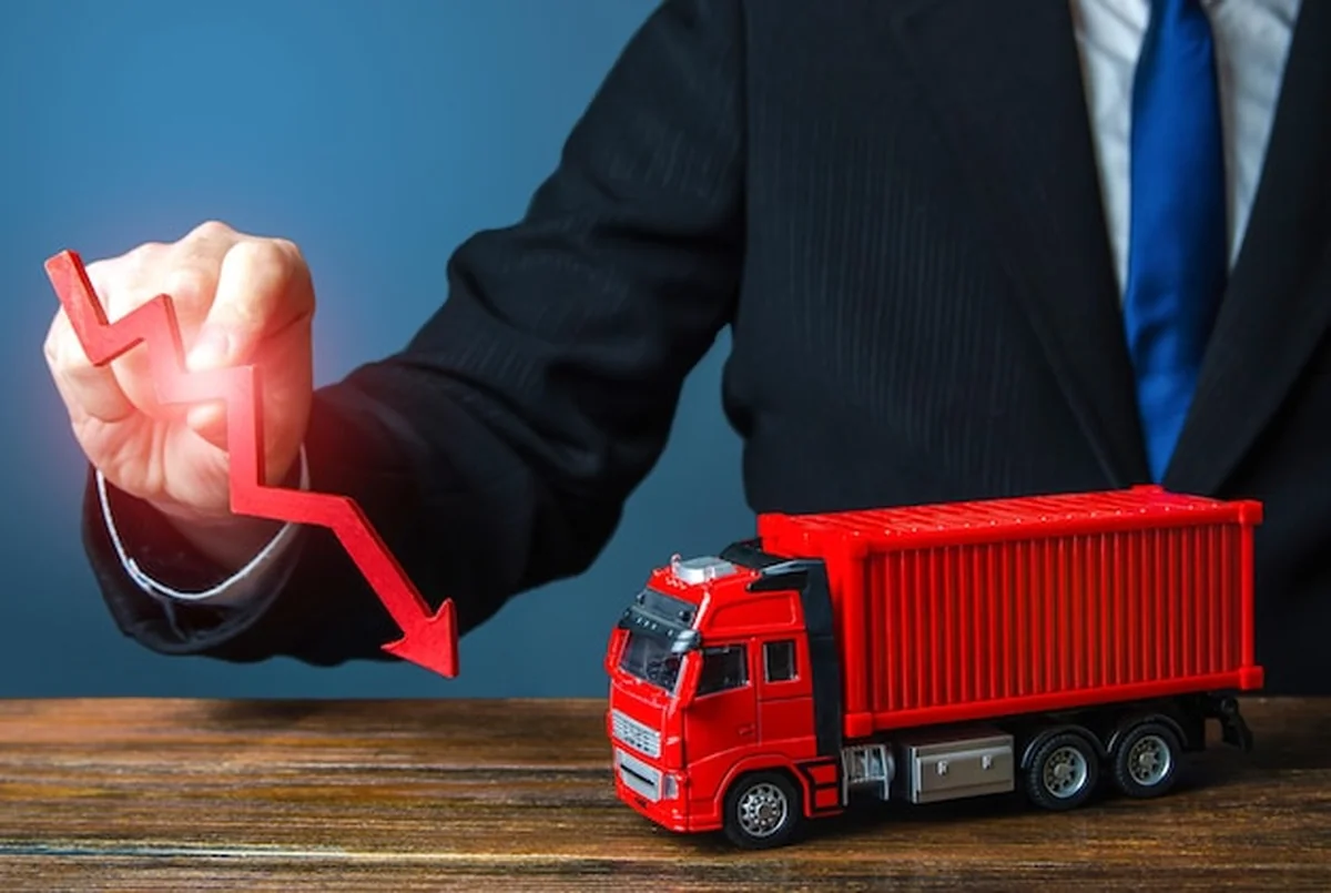 Biznesmen trzyma czerwoną strzałkę i ciężarówkę