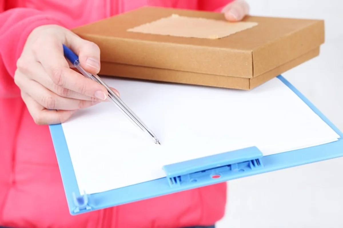 Kurier trzymający pudełko na przesyłki