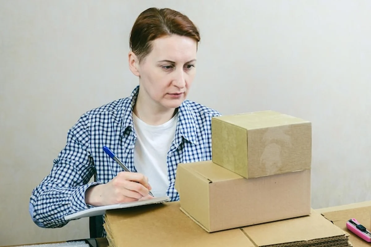 Kobieta biznesu pakuje zamówienia ze sklepu internetowego