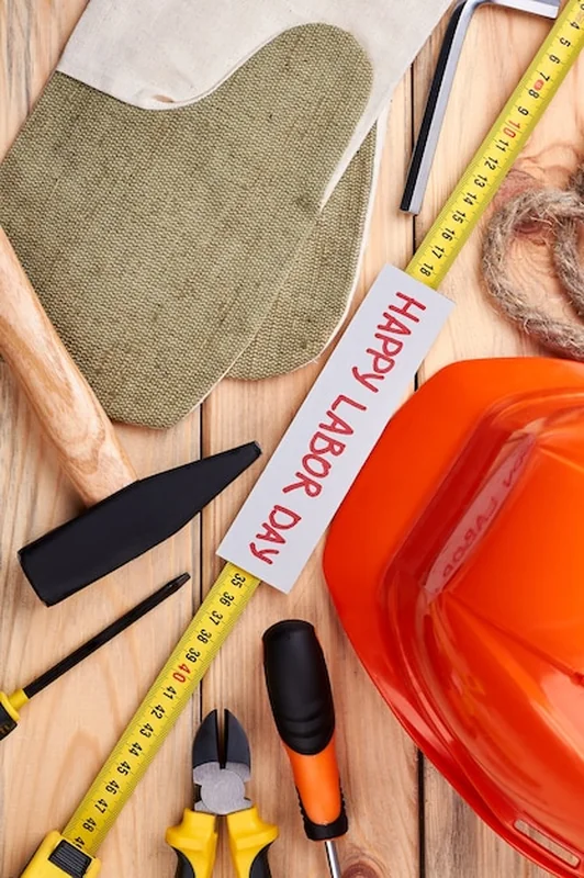 Młotek, kask i rękawice robocze na karcie Święta Pracy