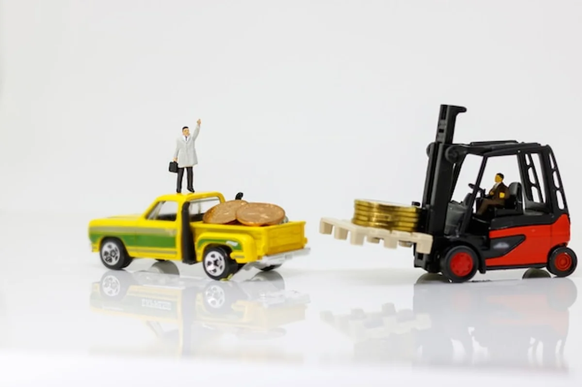 Pracownik przenosi stos monet do samochodu