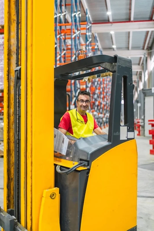 Pracownik magazynu prowadzący wóz widłowy