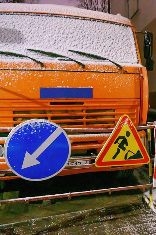 Ciężkie maszyny robocze na placu napraw drogowych w zimie