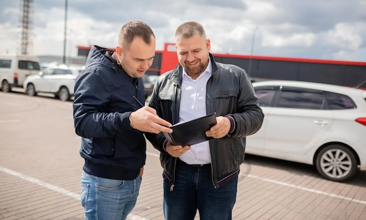 Klient kupujący samochód i podpisujący umowę - udana transakcja kupna sprzedaży samochodu