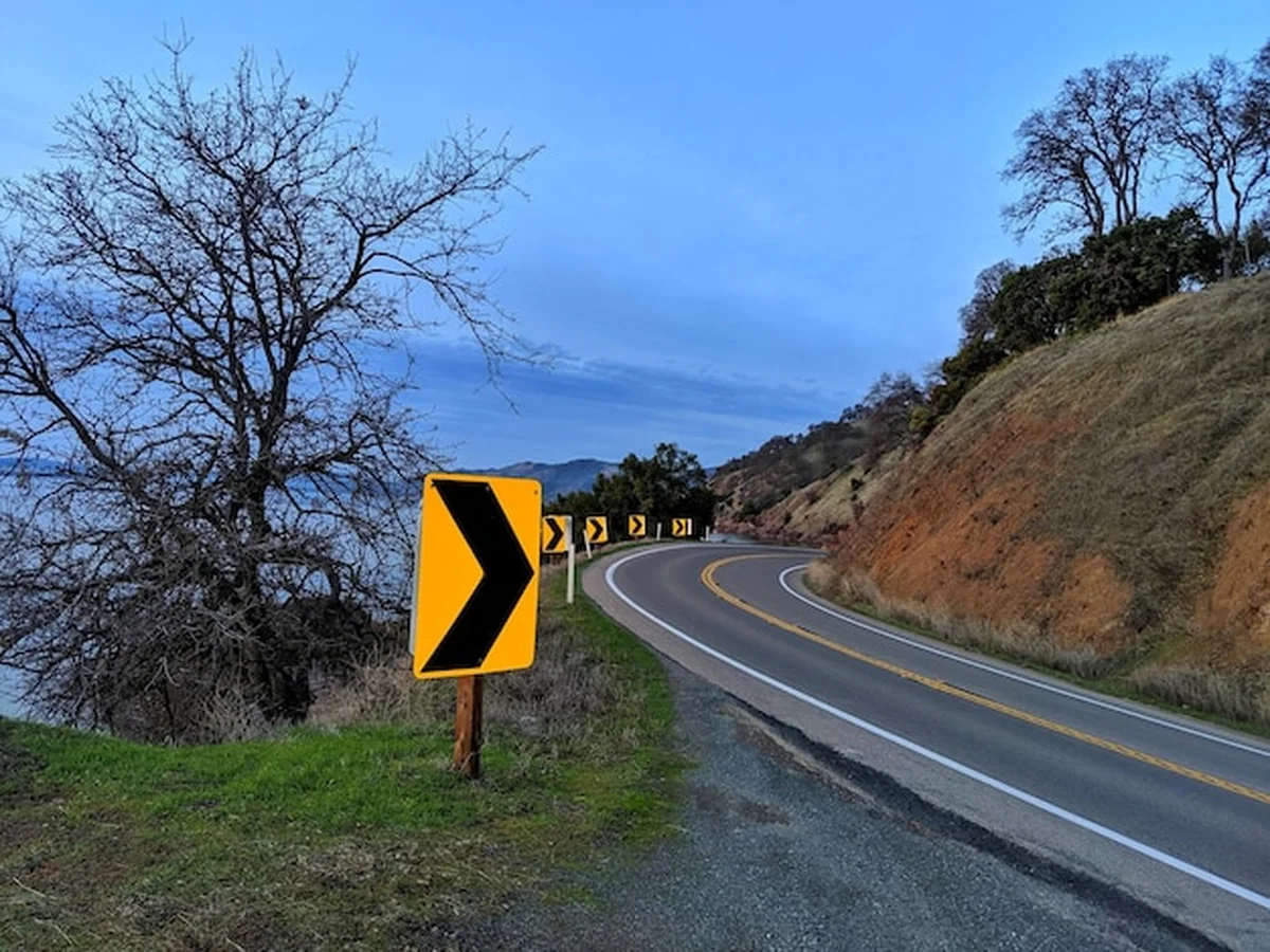 Znaki drogowe na górskiej autostradzie z widokiem jeziora
