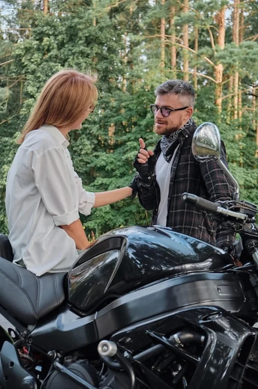 Para w średnim wieku na motocyklu w lesie
