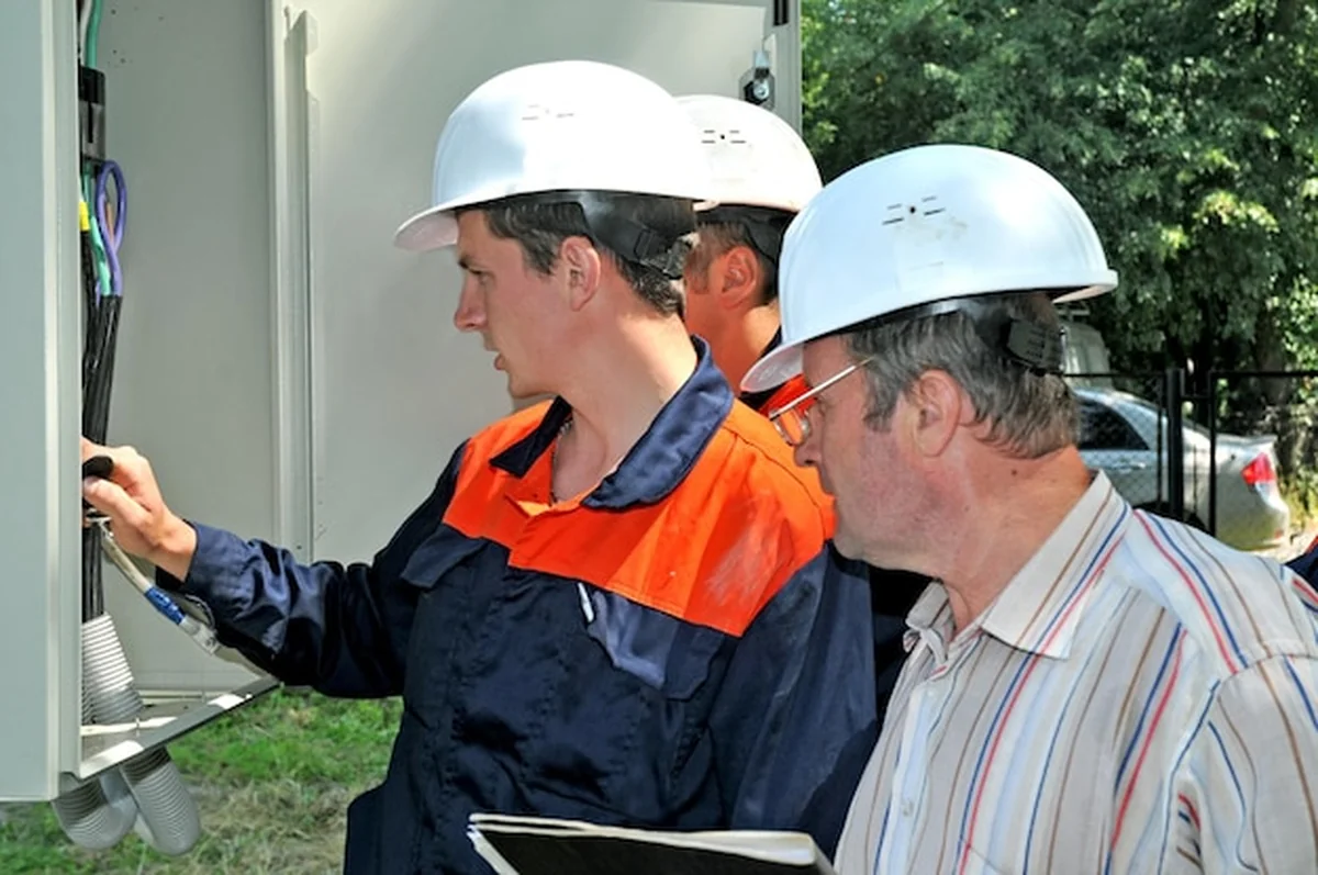 Inżynier elektryk wyłącza napięcie w szafie sterowniczej