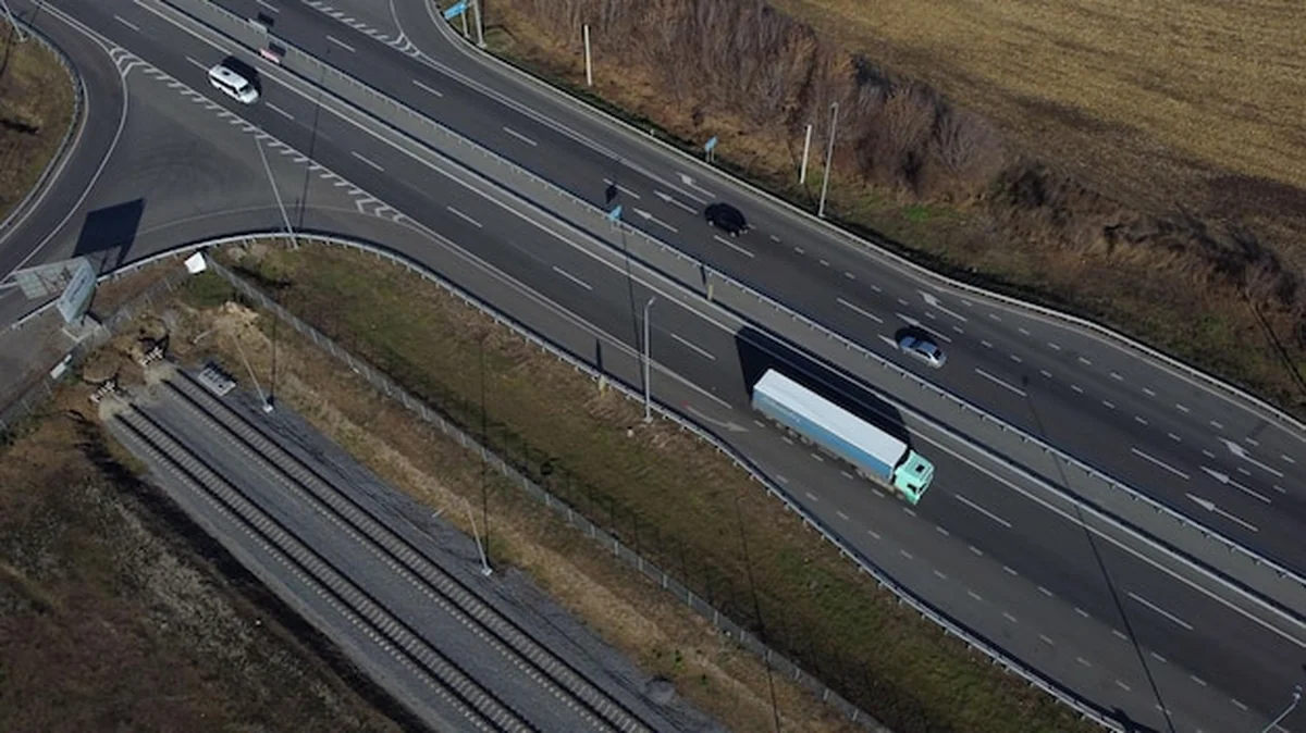 Autostrada prowadząca samochody przez pola uprawne po zbiorach w słoneczny jesienny dzień