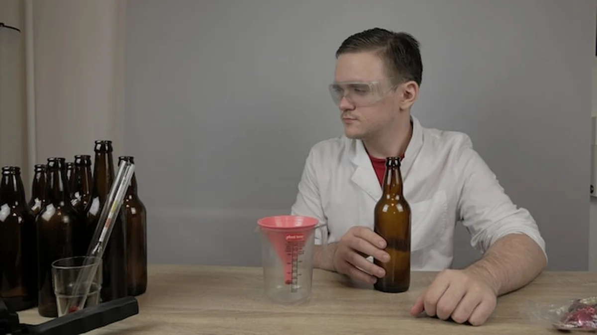 Młody piwowar przygotowuje produkty i sprawdza jakość sprzętu